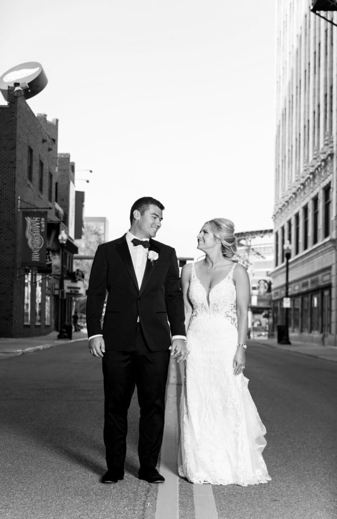 bride and groom holding hands and walking down the streets in downtown Detroit