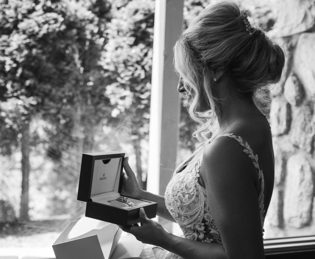bride opening a Rolex watch gift on her wedding day