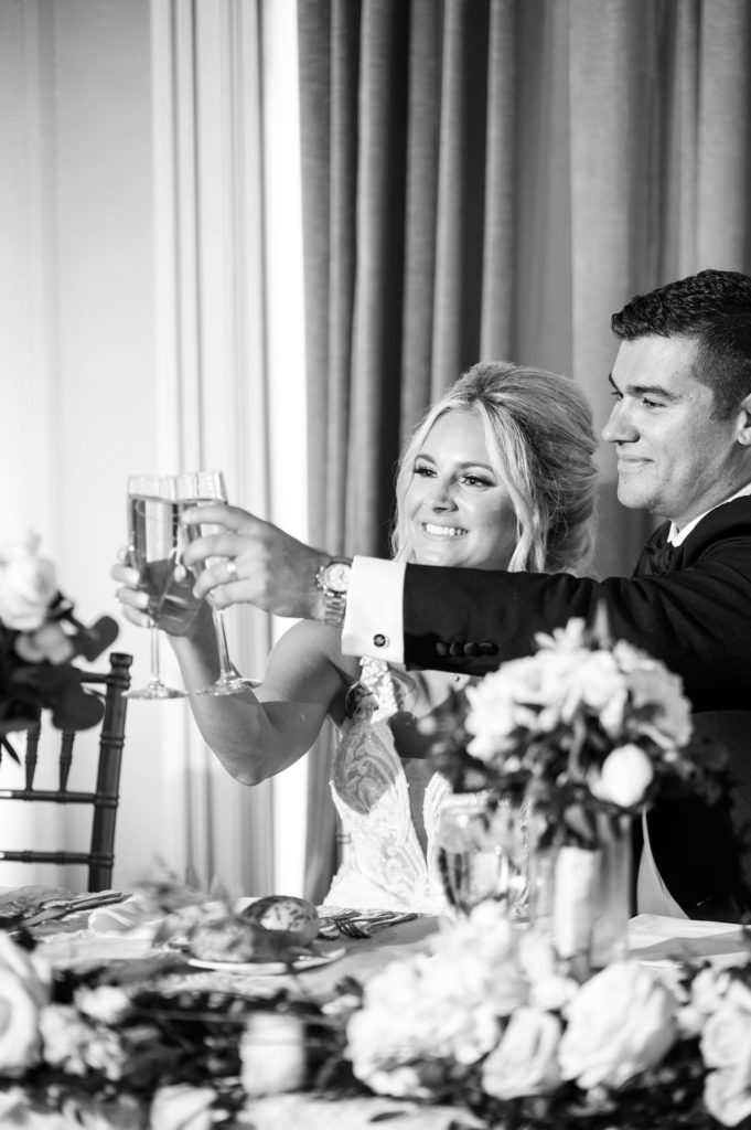 bride and groom toast their champagne glasses during their reception at the Colony Club Detroit