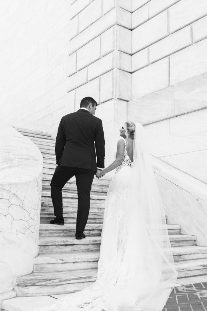 a candid wedding portrait of the bride and groom on the marble steps of the Detroit Institute of Arts