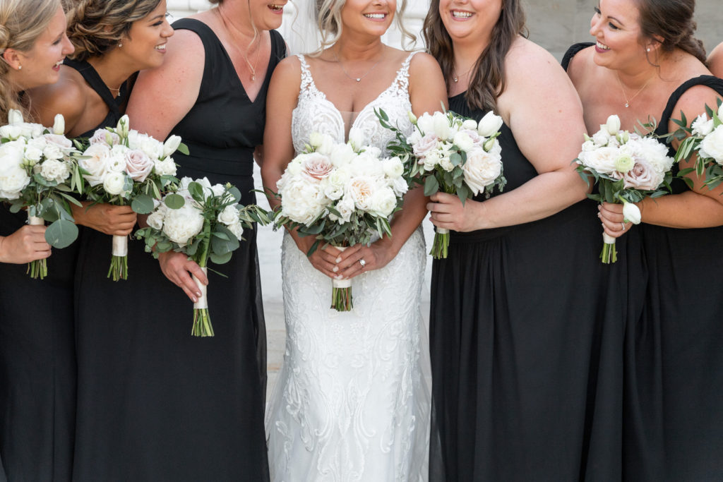 black bridesmaid dresses and white floral arrangements