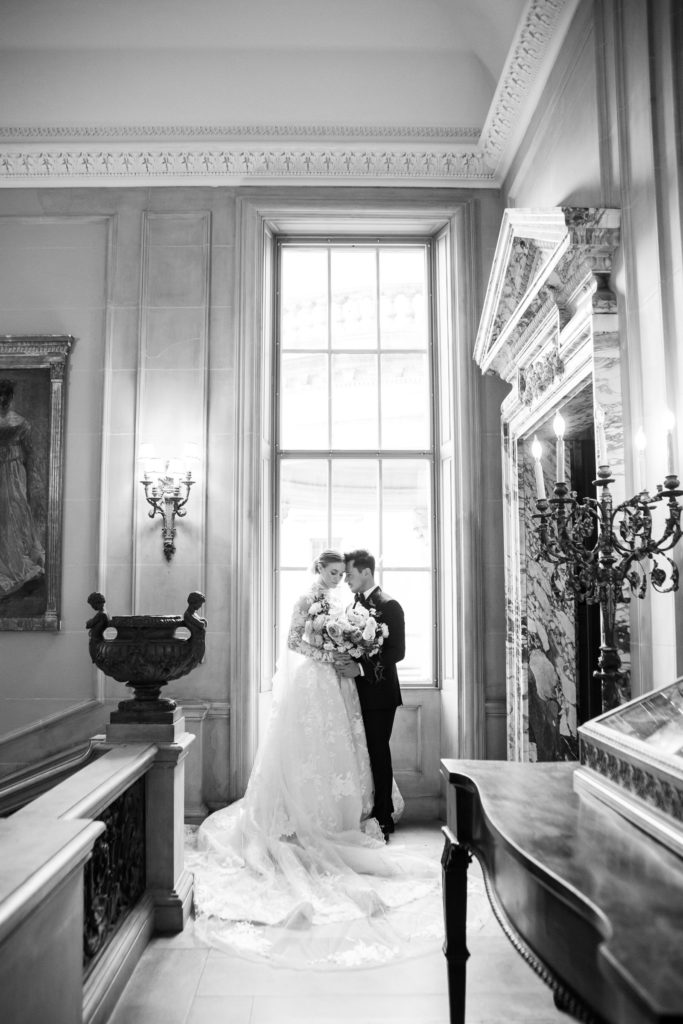 bride and groom snuggled in front of a window at the Anderson House