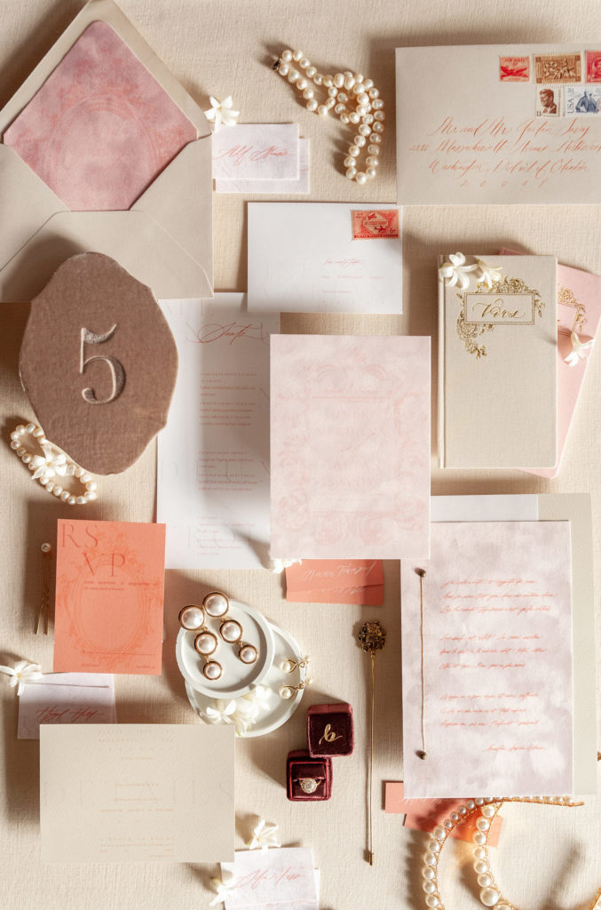 pink and tan wedding details flat lay