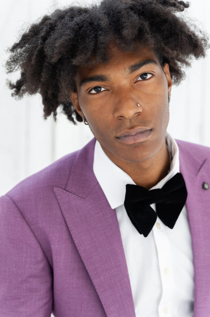 African american groom in a purple suit coat looking directly at the camera 