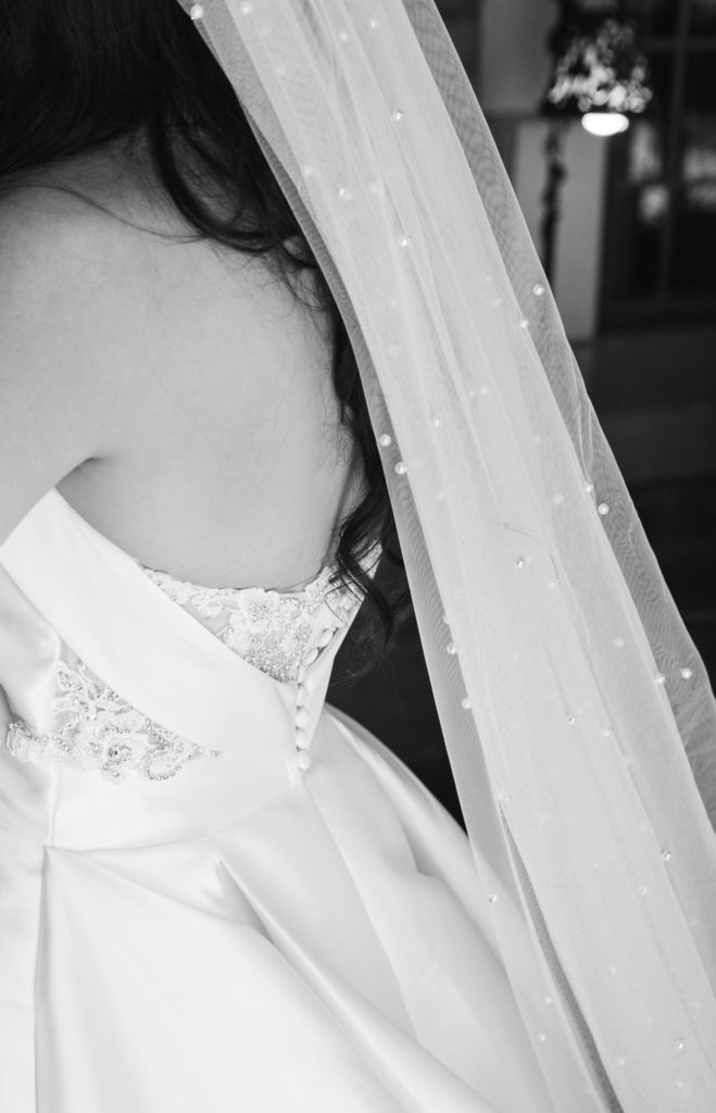 white strapless satin wedding dress with a beaded veil