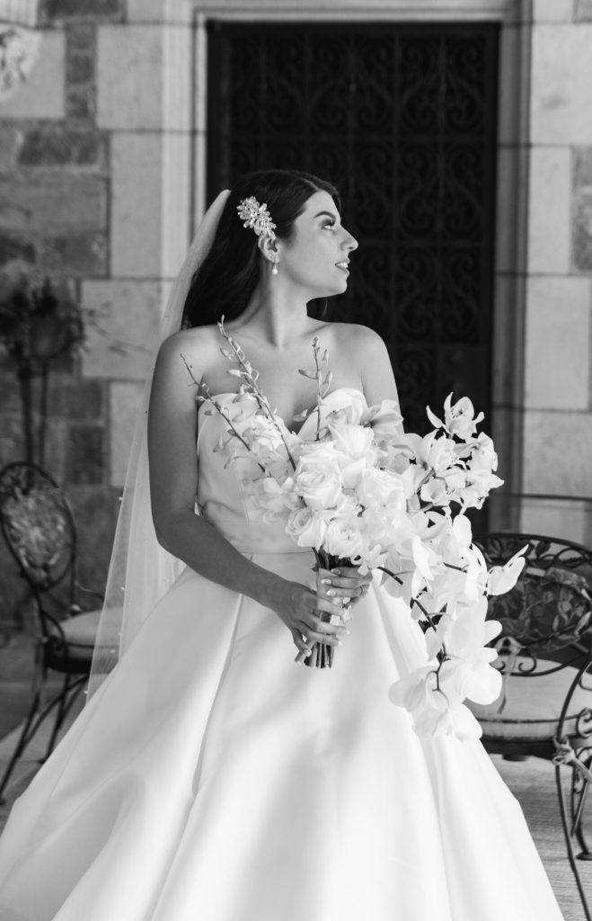 classic bride holding a white bouquet looking over her shoulder 