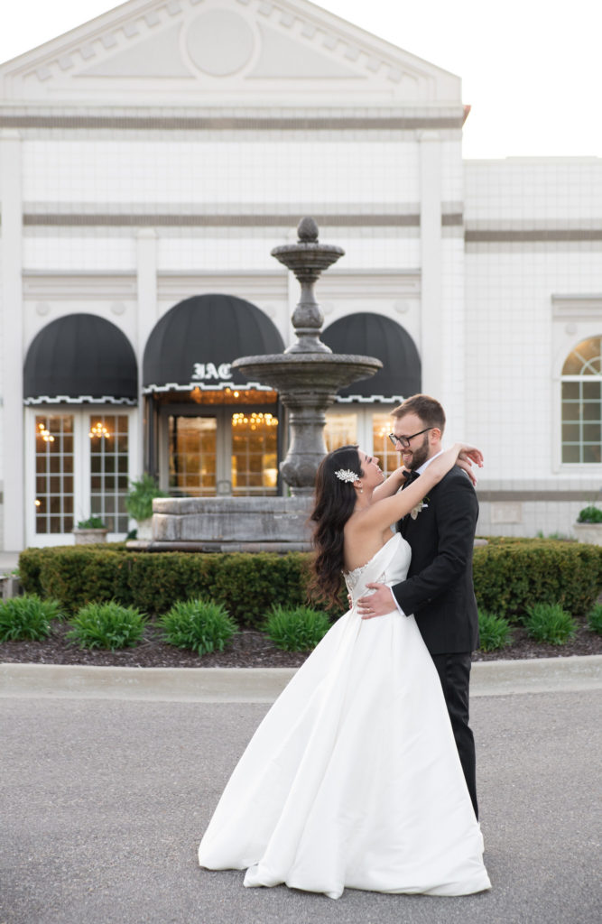 bride and groom hugging in front a classic Detroit wedding venue
