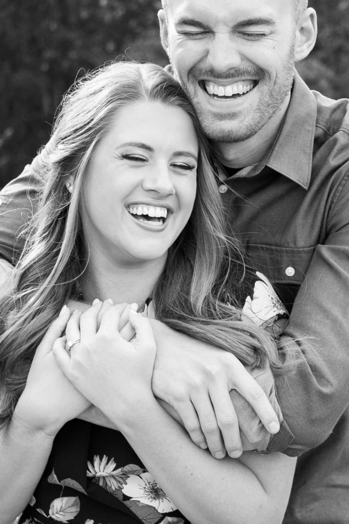man and woman hugging and laughing in black and white