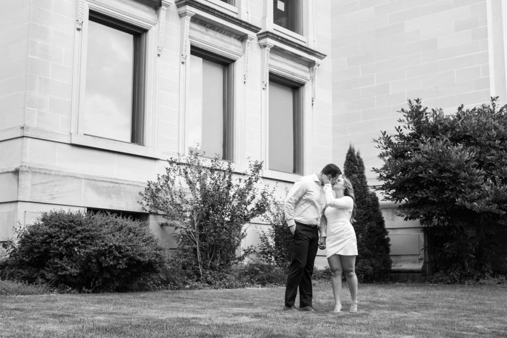 couple kissing in front of the Manistee public library