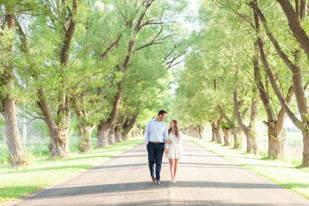 couple holding hands and walking during their Manistee Michigan engagement pictures