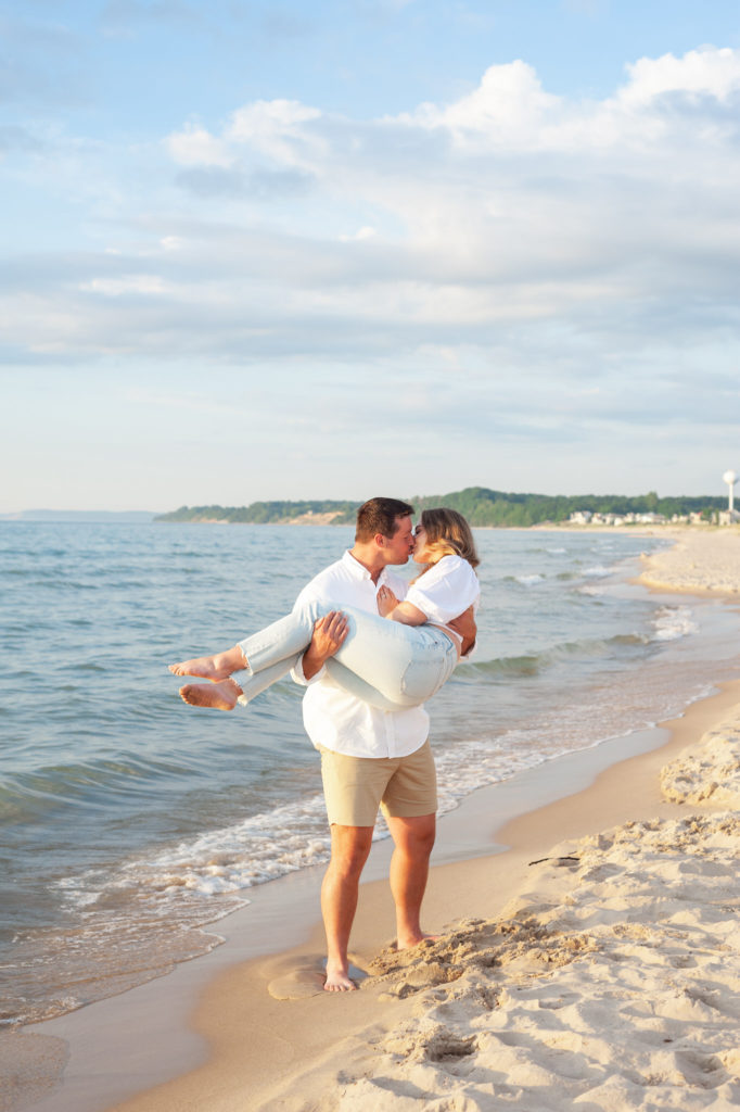 man holding a woman kissing her on the beach
