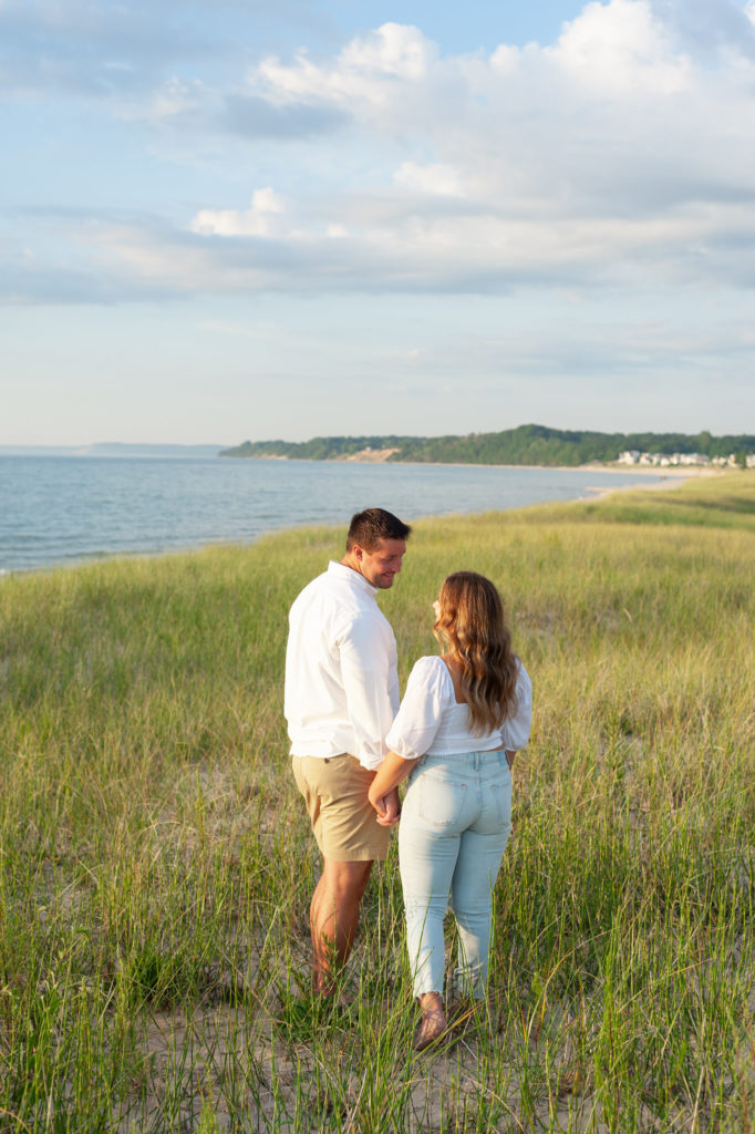 man and woman holding hands on the shore of Lake Michigan
