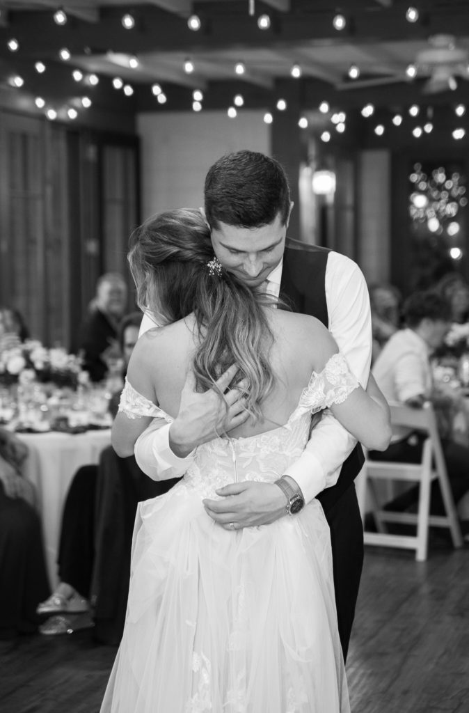 black and white picture of bride and groom having their first dance 