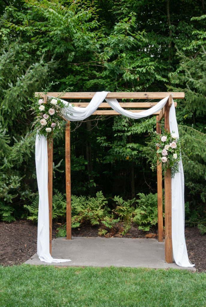 wedding ceremony arbor in front of a forest