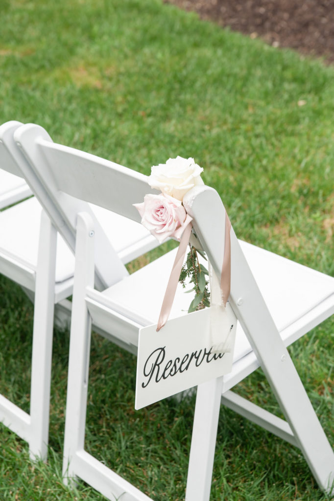 white wedding ceremony chair with a reserved sign