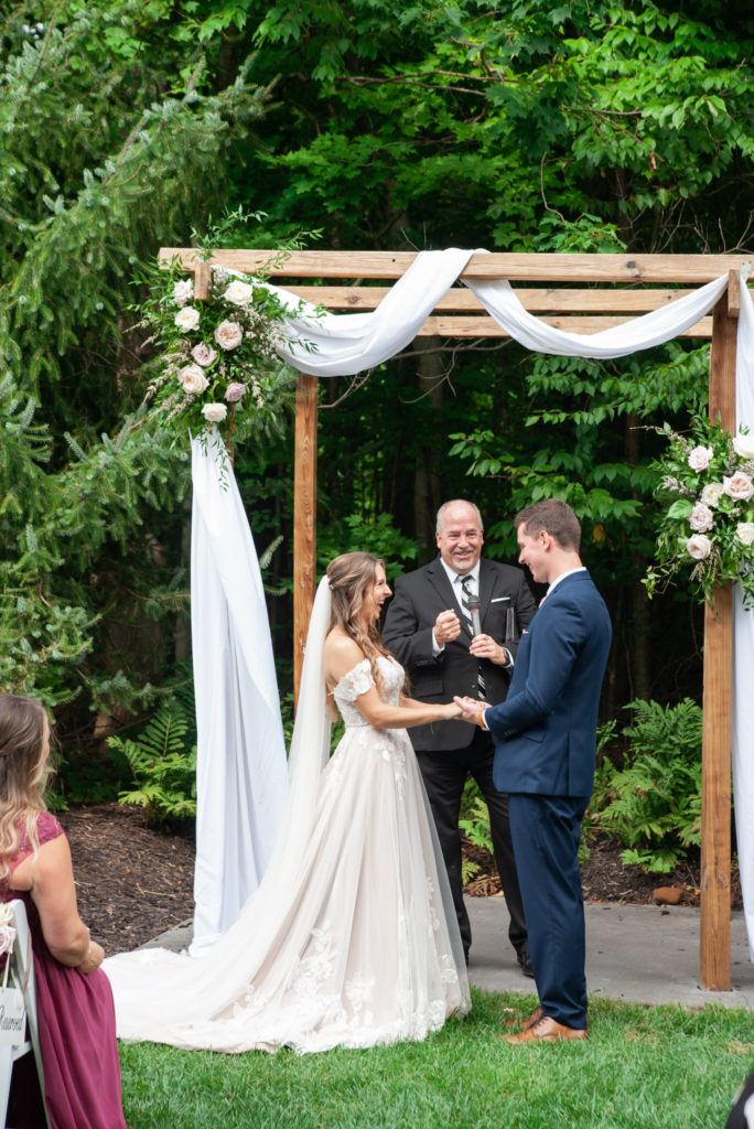bride and groom holding hands during their outdoor wedding ceremony at Ravines Golf Club