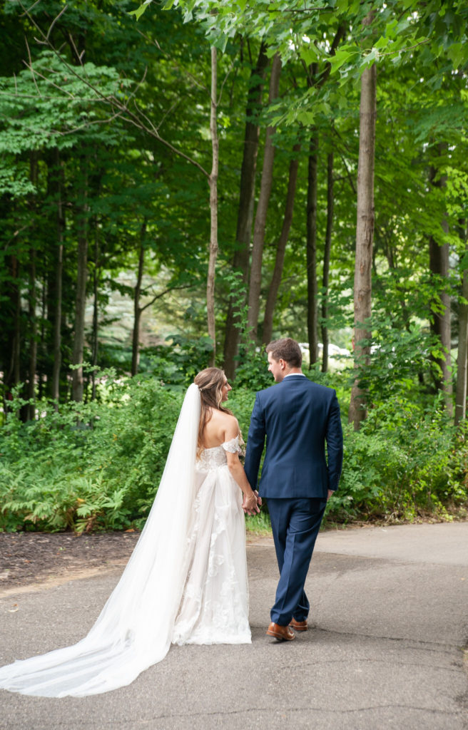 bride and groom walking away in a forest