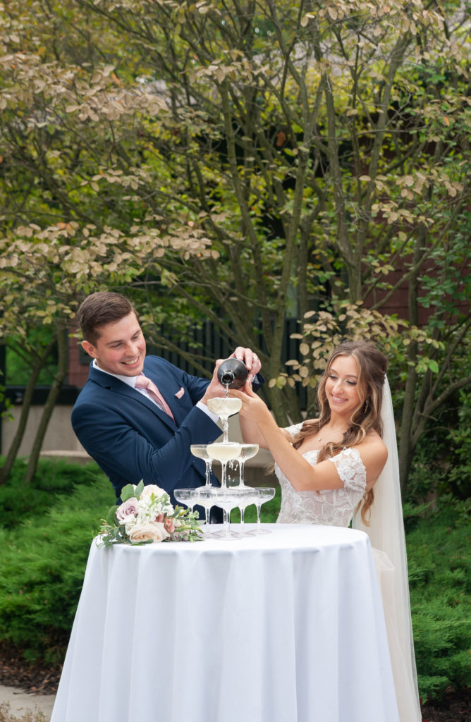 bride and groom pouring champagne over a champagne tower