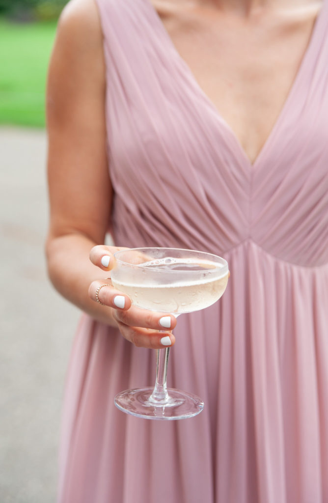 bridesmaid in a pink dress holding a champagne glass