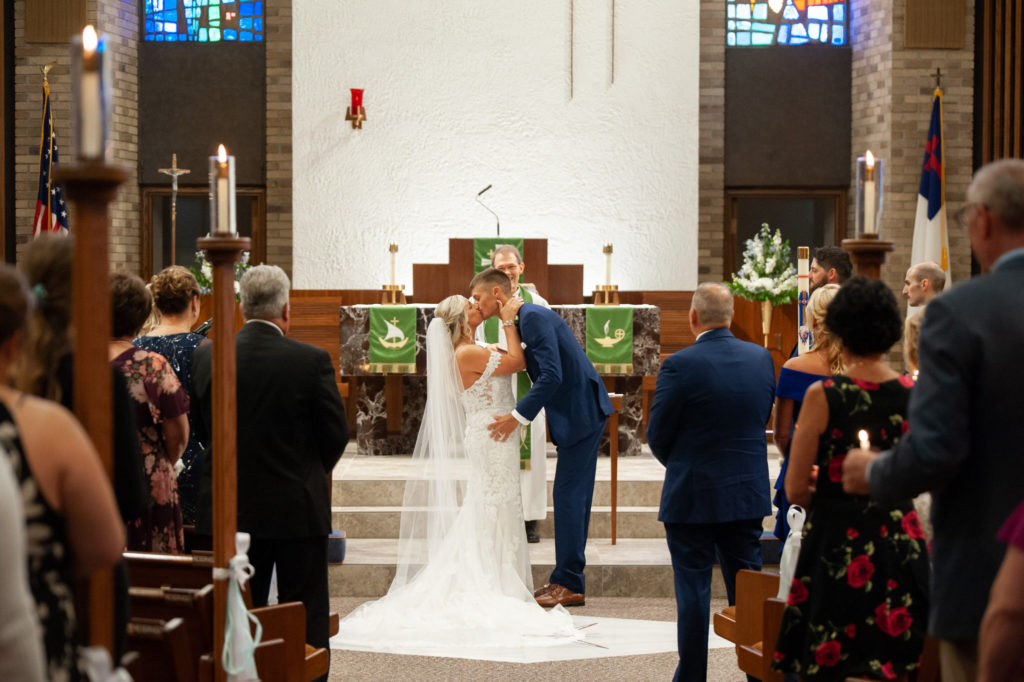 bride and groom share their first kiss after their wedding ceremony at St. Michael's Lutheran Church in Richville, Michigan