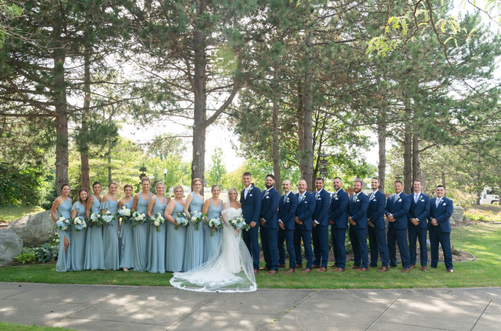 bridal party in light blue bridesmaids dresses and navy suites