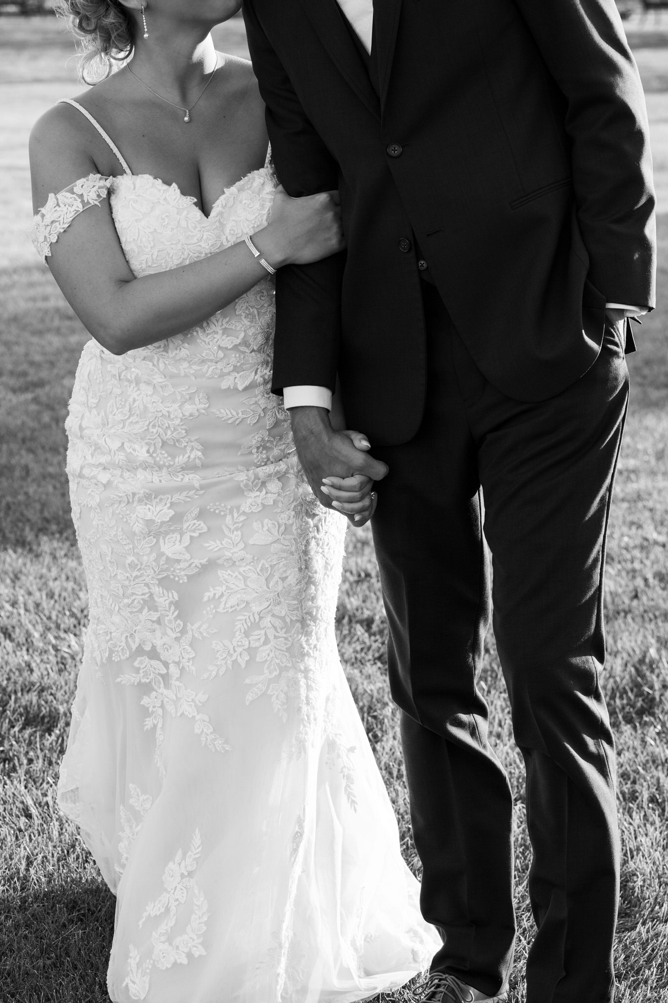 bride and groom holding hands while walking towards the camera