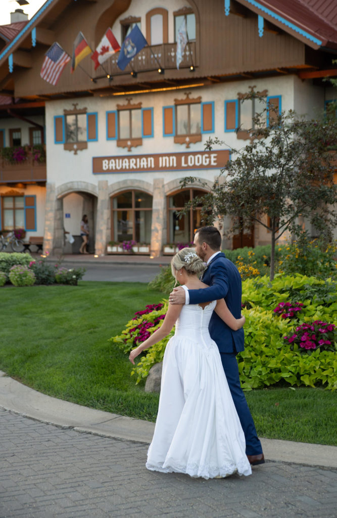 bride and groom walking outside the Bavarian Inn Lodge in Frankenmuth at sunset