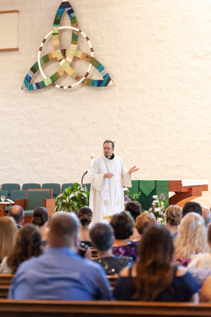 pastor preaching to the congregation at Blessed Trinity Catholic Church