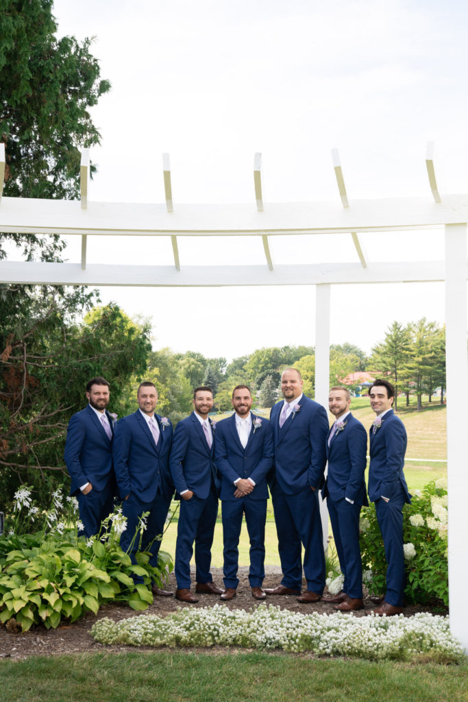 groomsmen in navy suits smiling at the camera in Frankenmuth Michigan
