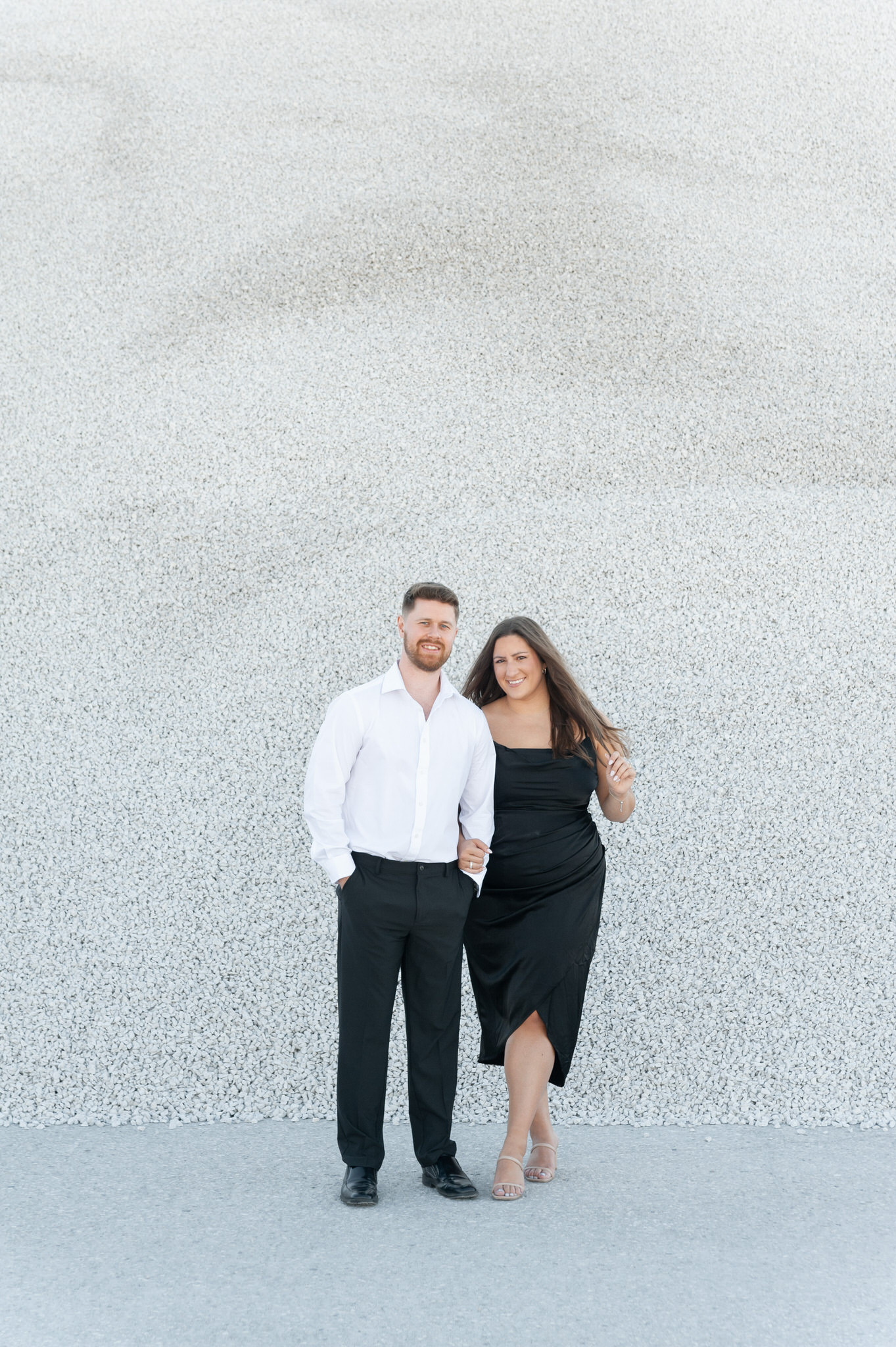 couple smiling at the camera in front of the gravel pits in Holland Michigan