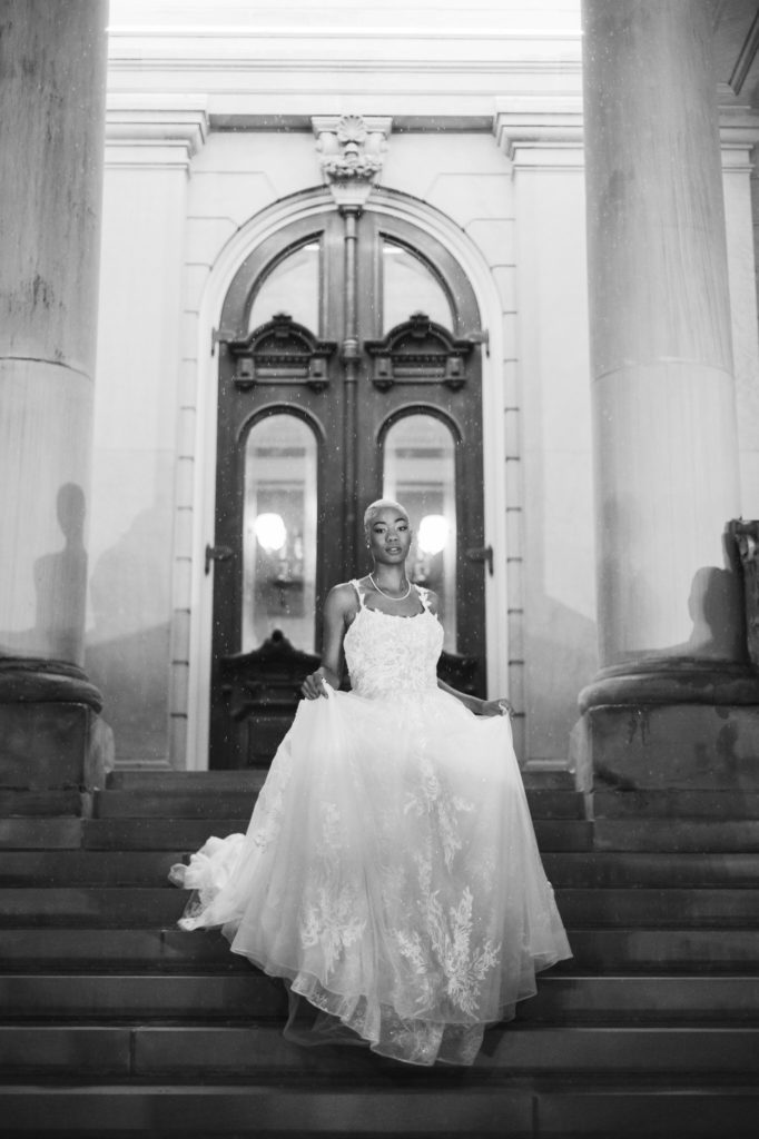 African American bride walking down the steps of the Michigan Capitol building in the snow
