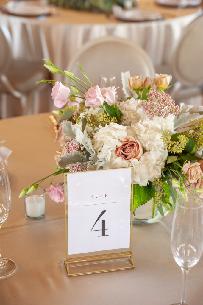 wedding reception table number four with a pink and white floral bouquet