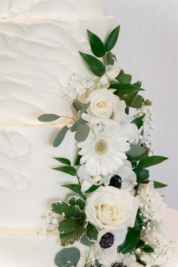 white flowers climbing around a white wedding cake