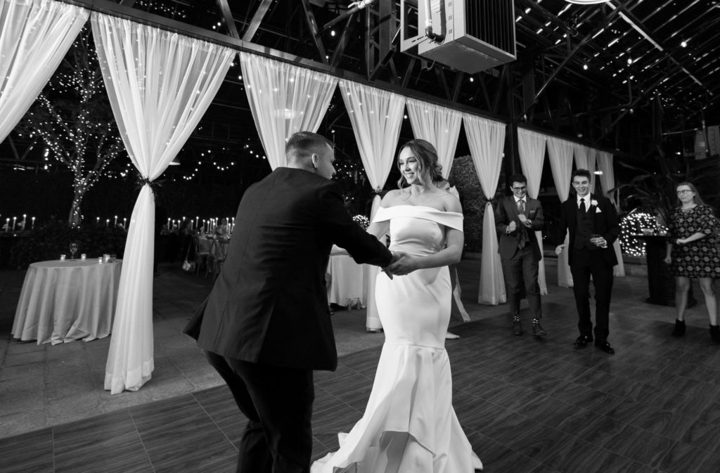 bride and groom holding hands and dancing the night away during their wedding reception at Planterra Conservatory