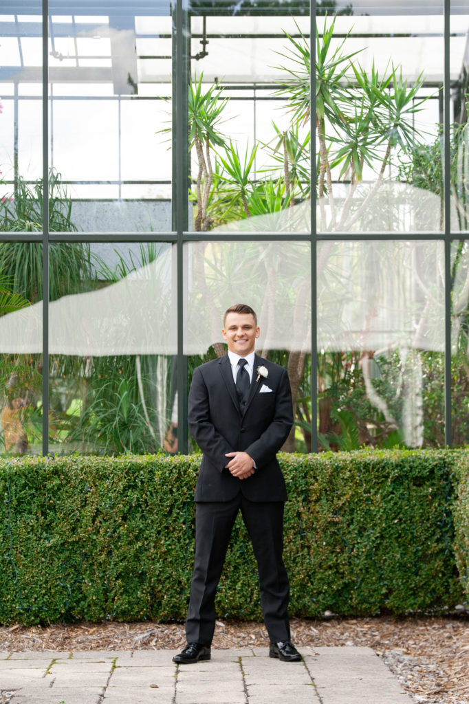 groom posing for a photo on his wedding day at Planterra