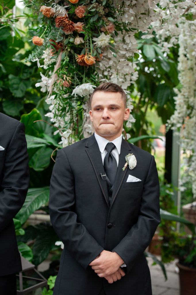groom gets emotional as he sees his bride walking down the aisle for the first time 