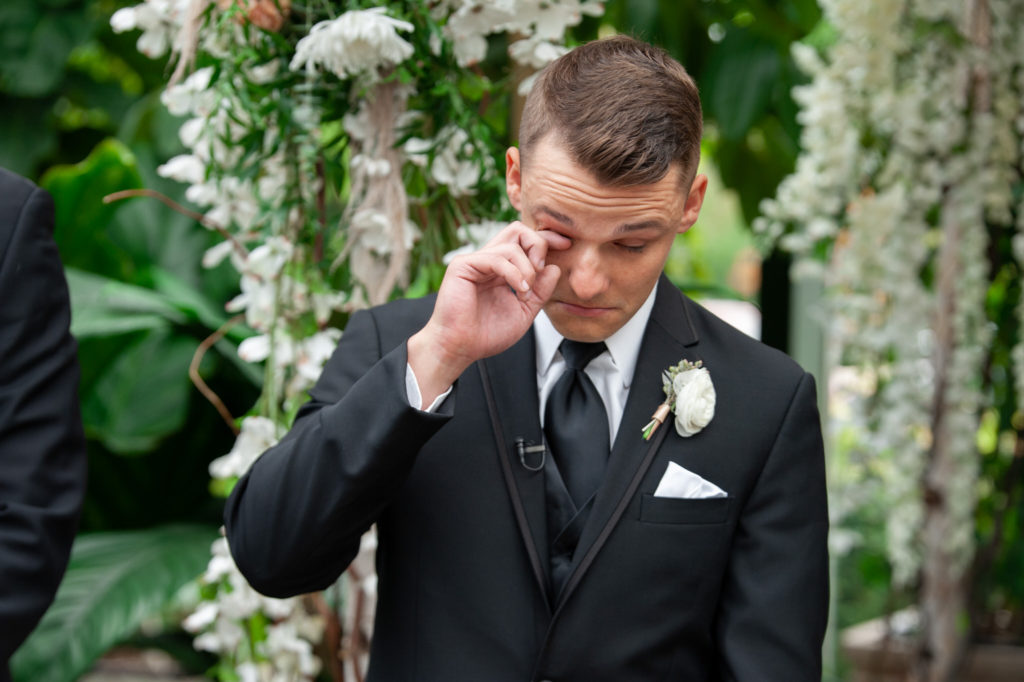 groom sheds a tear as he sees his bride walk down the aisle