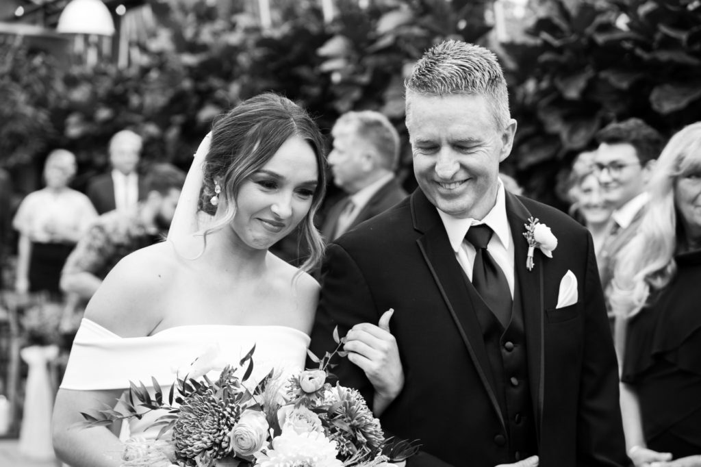 bride shares an emotional moment with her father as he walks her down the aisle