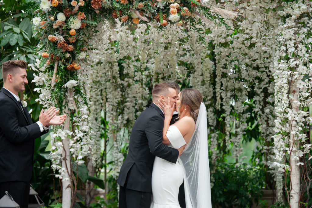 bride and groom kiss after their Planterra Conservatory wedding reception