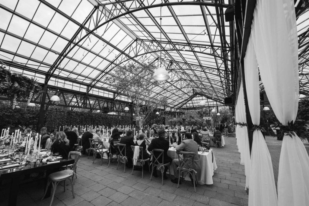 wide angle of a fall wedding reception inside the Planterra Conservatory in West Bloomfield, MI