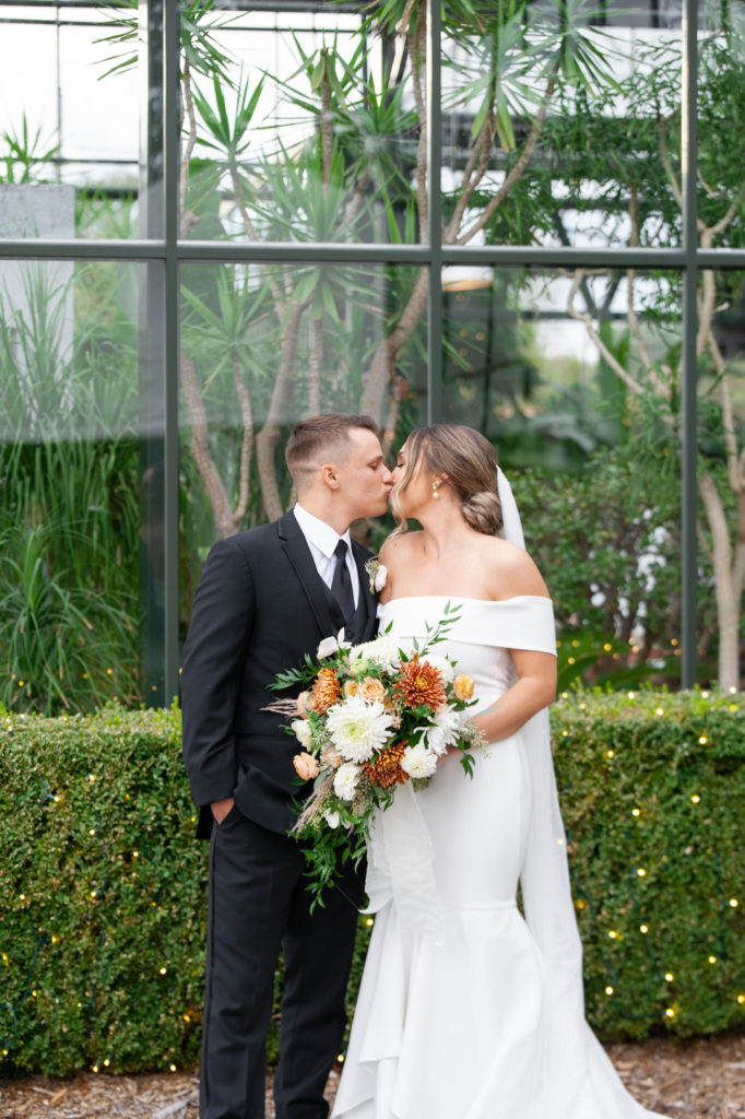 A couple who decided to get married at Planterra Conservatory in West Bloomfield, MI share a kiss.
