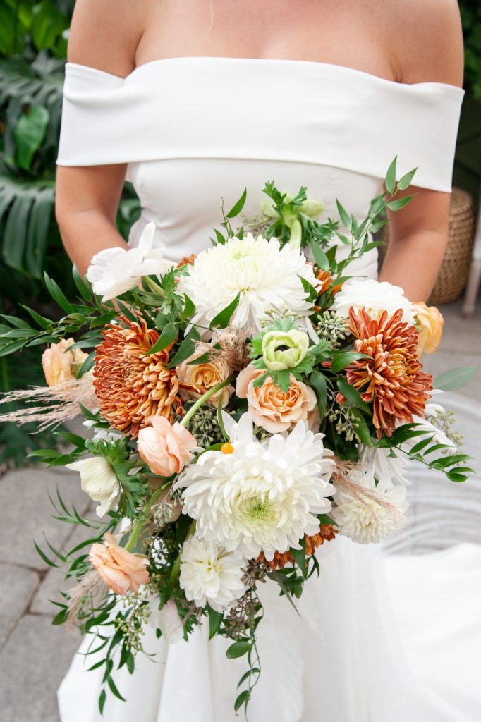 a beautiful bridal bouquet of orange, pink and white flowers