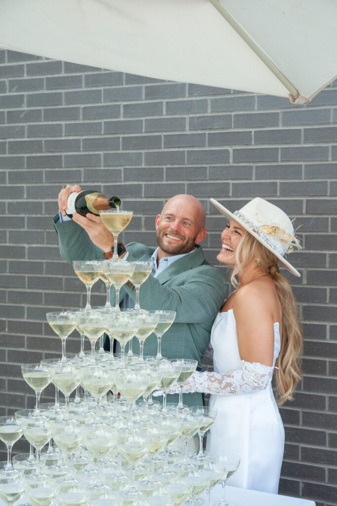 bride and groom pouring champagne into their champagne tower