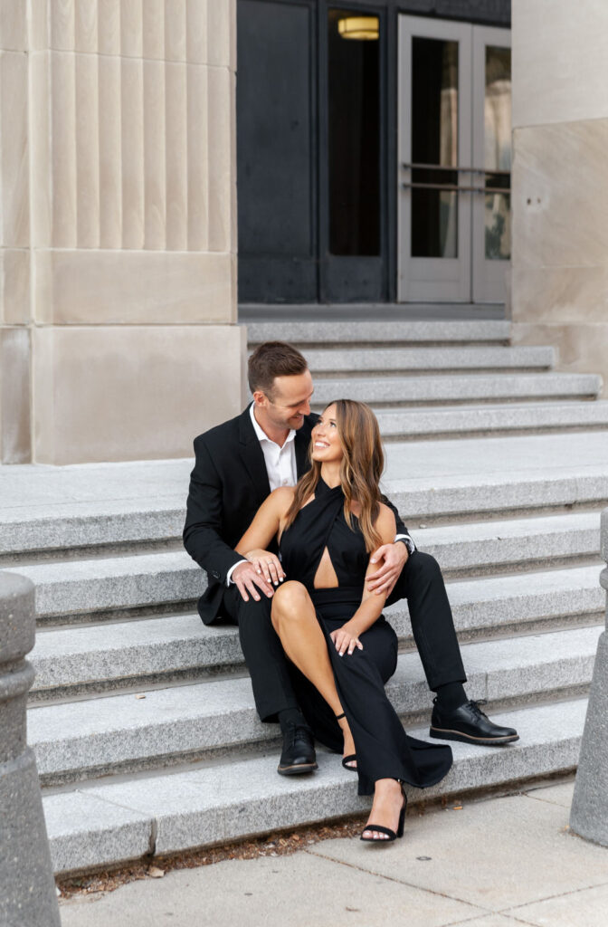 elegant engagement photo of couple sitting on the stairs of the Civic Auditorium in downtown Grand Rapids