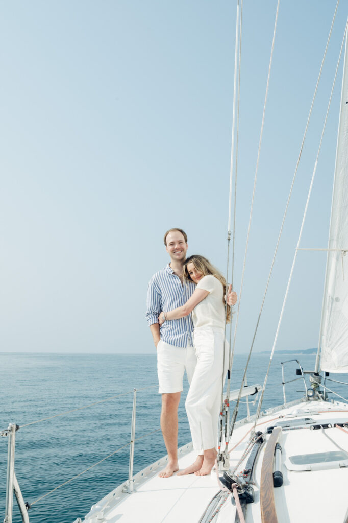 man and woman hugging on the bow of a sailboat