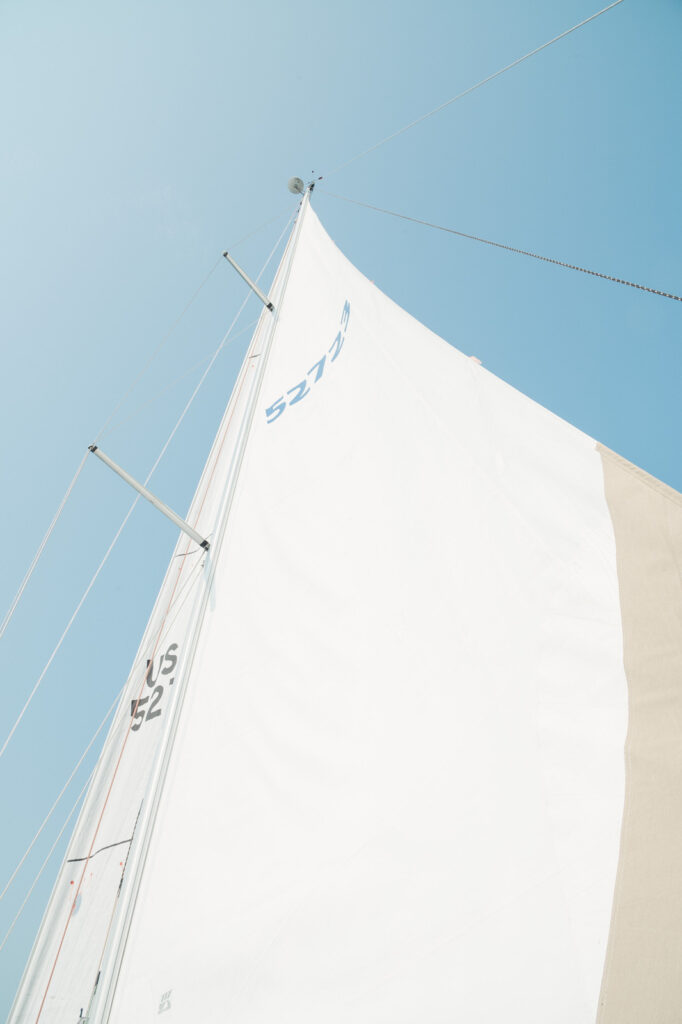 the sail of a private chartered sailboat out of Lake Michigan with full sun and pure blue skies