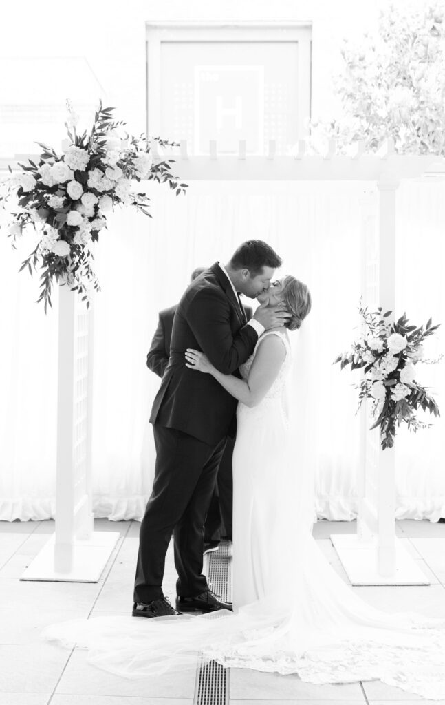 bride and groom kiss during their wedding at the H Hotel in Midland, Michigan