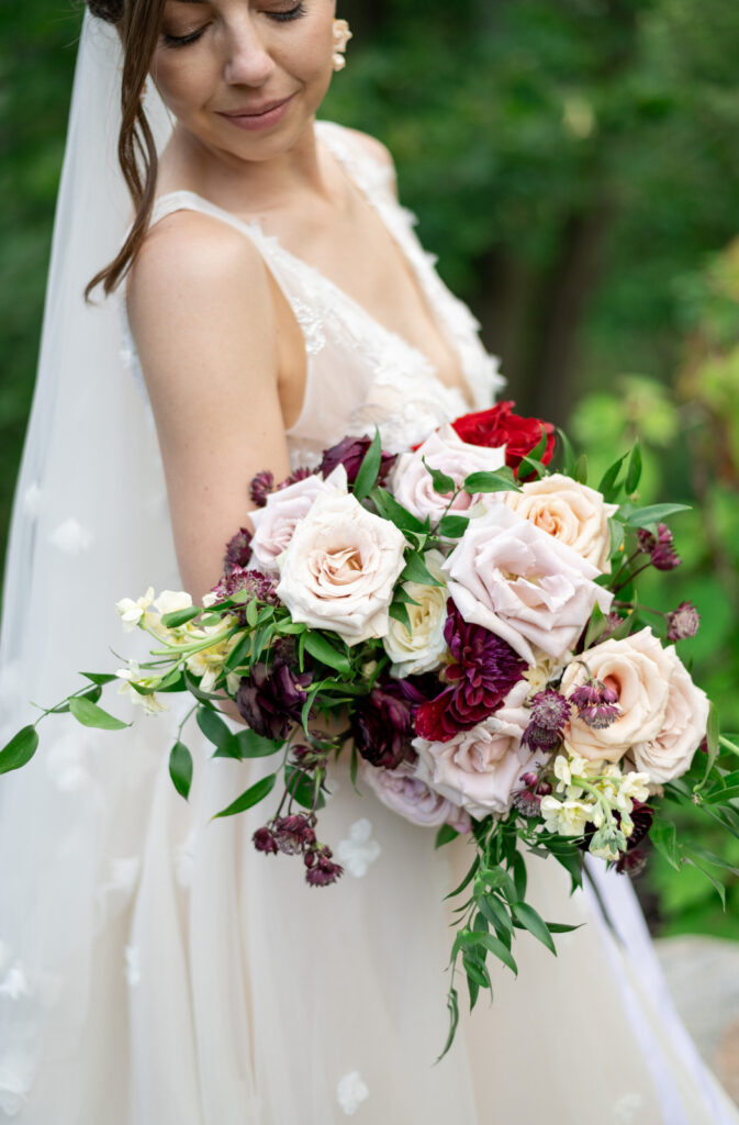 wedding bouquet made up of pink, red and white garden roses and greenery
