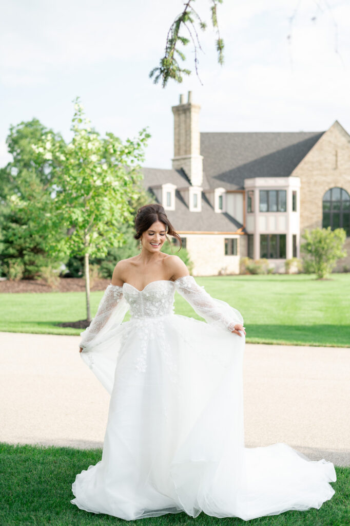bride holding and twirling the Astoria gown by Eva Lendel in front of Venue3Two in Grand Rapids, Michigan