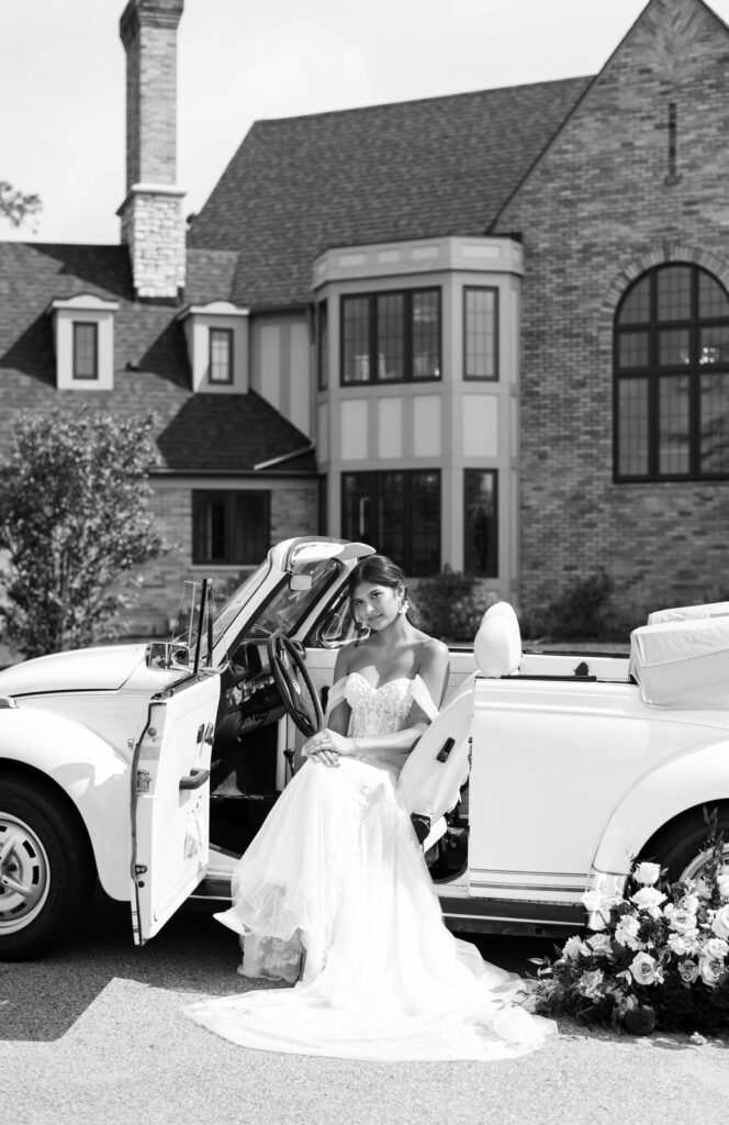 bride sitting in a vintage white car in front of Venue3Two in Grand Rapids, Michigan